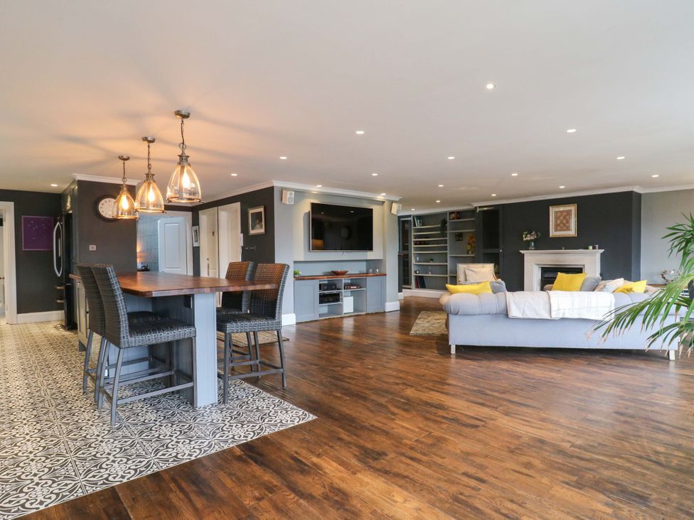 A living room with a sofa and television at River Haven in Thames Ditton