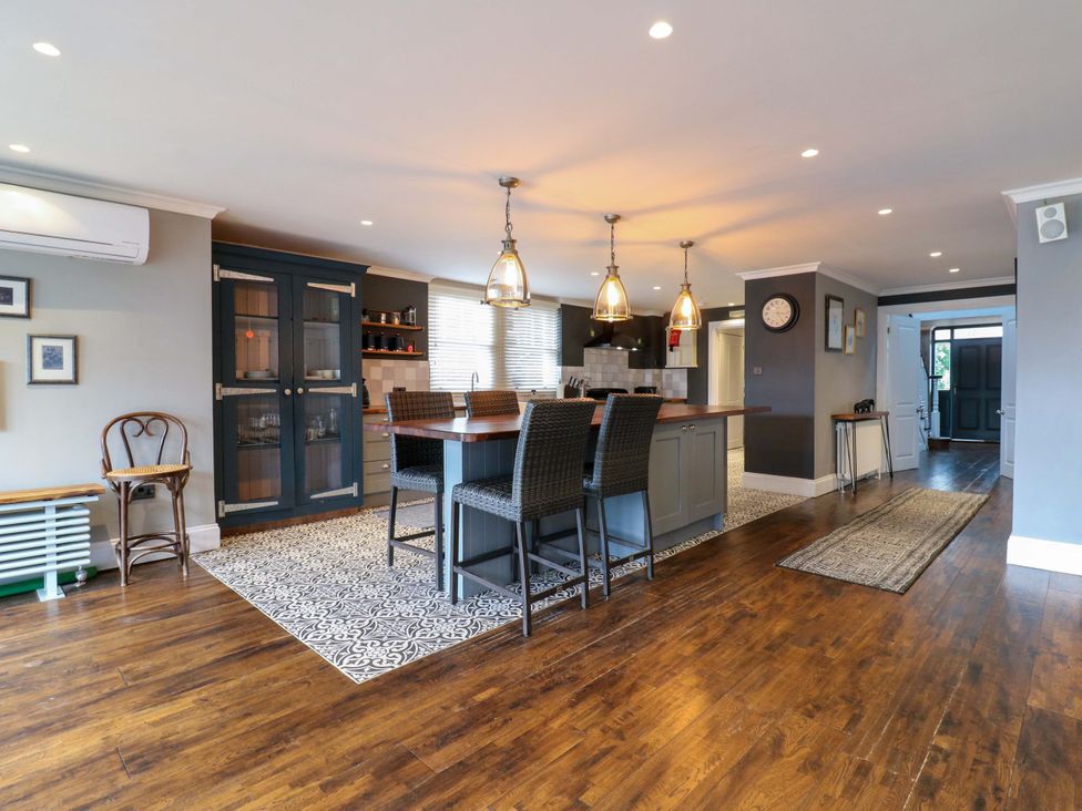 A kitchen with a central island and bar stools at River Haven in Thames Ditton