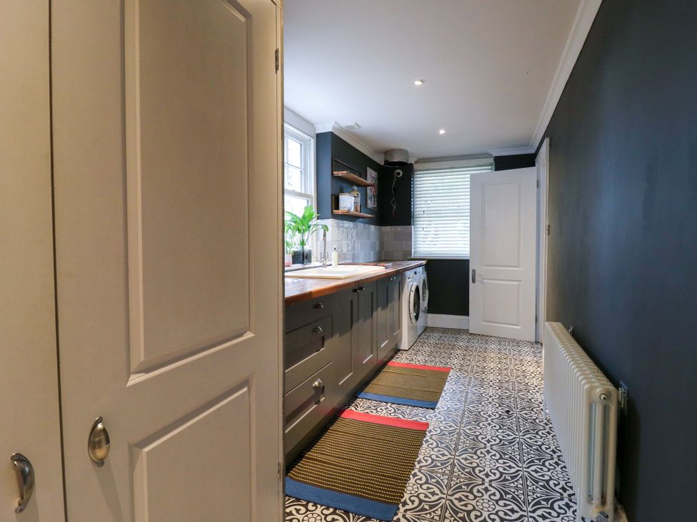 A kitchen with cabinets and a washer at River Haven Thames Ditton