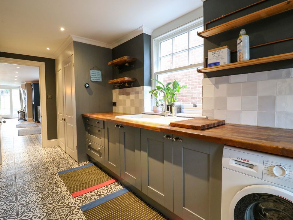 A kitchen with a sink and wooden countertop at River Haven in Thames Ditton