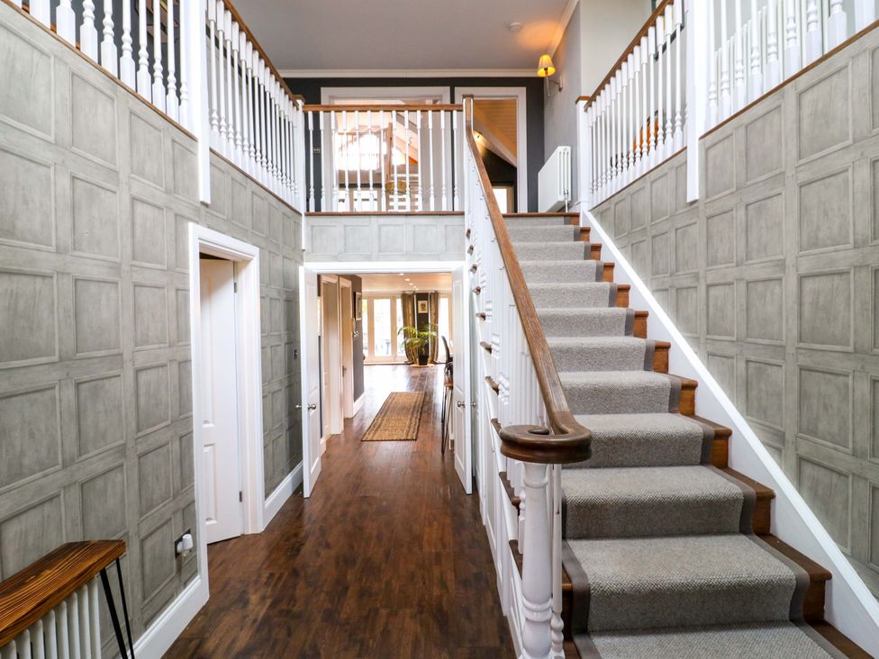 A staircase and hallway with doors at River Haven in Thames Ditton
