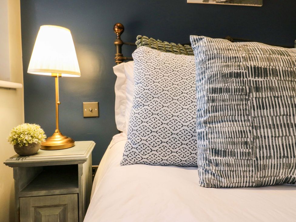 A bedroom with a bed and bedside table at River Haven in Thames Ditton