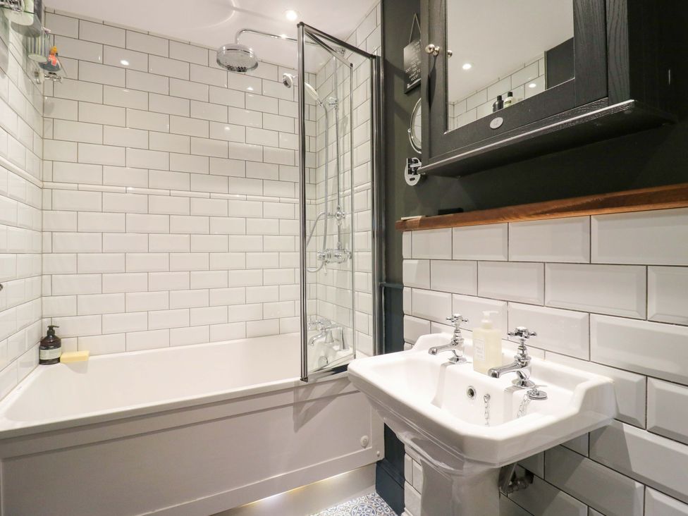 A bathroom with a bathtub and sink at River Haven in Thames Ditton