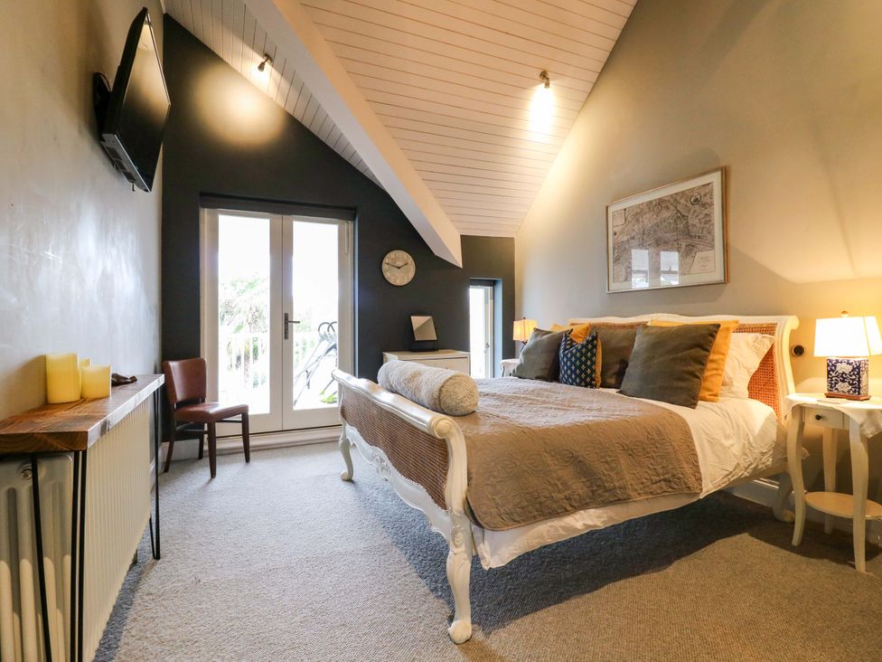 A bedroom with a bed and TV at River Haven Thames Ditton