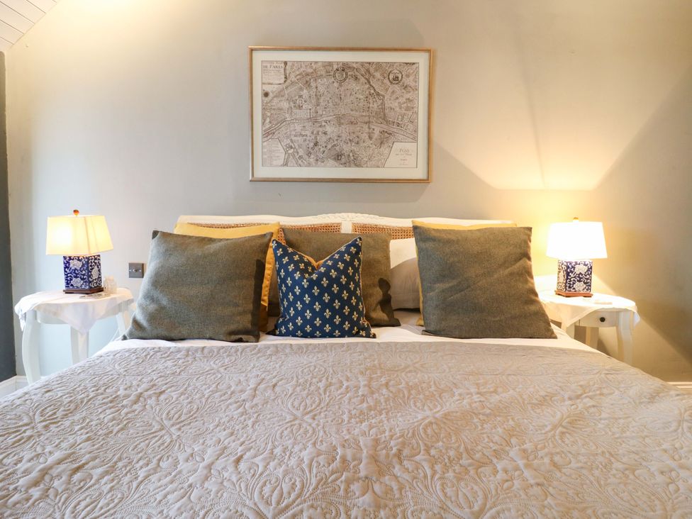 A bed with pillows and lamps in a bedroom at River Haven Thames Ditton