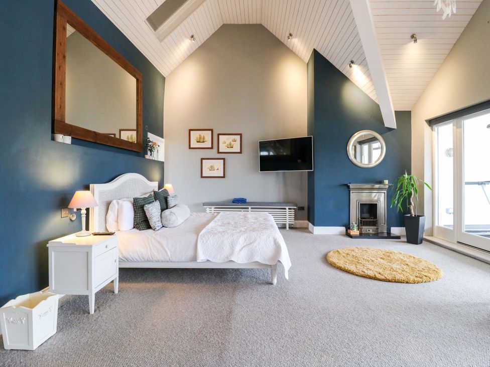 A bedroom with a bed and television at River Haven in Thames Ditton