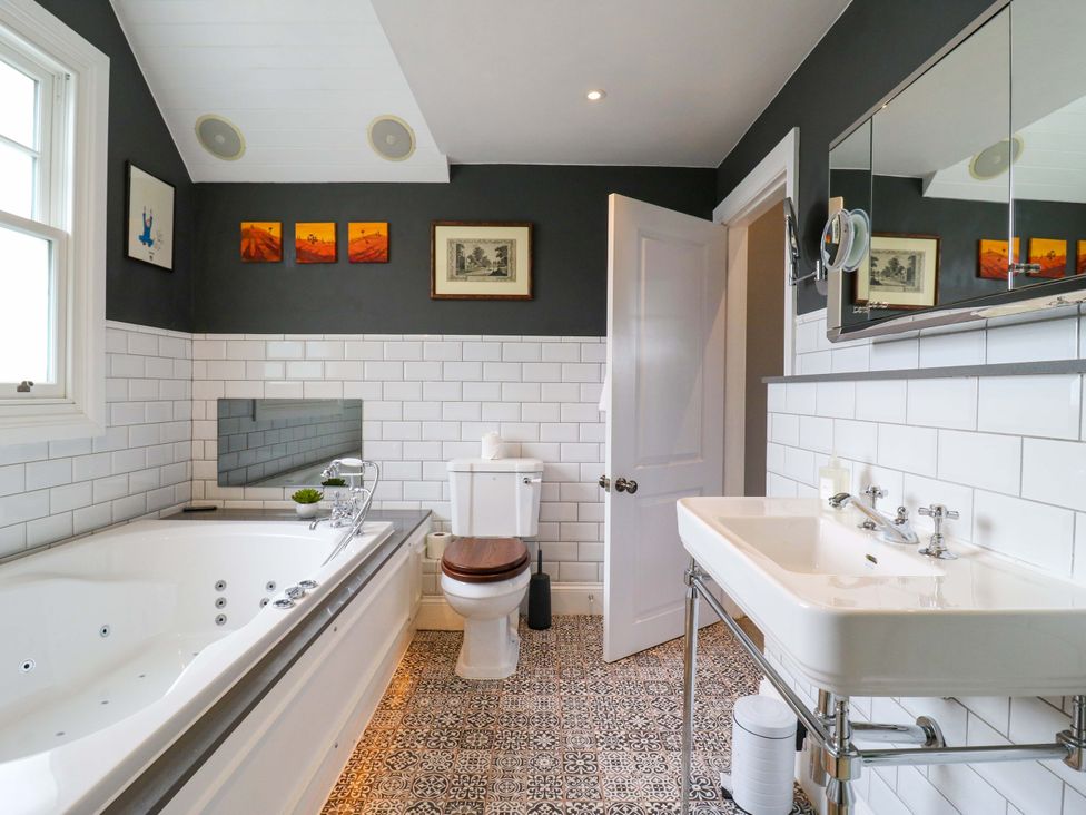 A bathroom with a bathtub, toilet and sink at River Haven in Thames Ditton