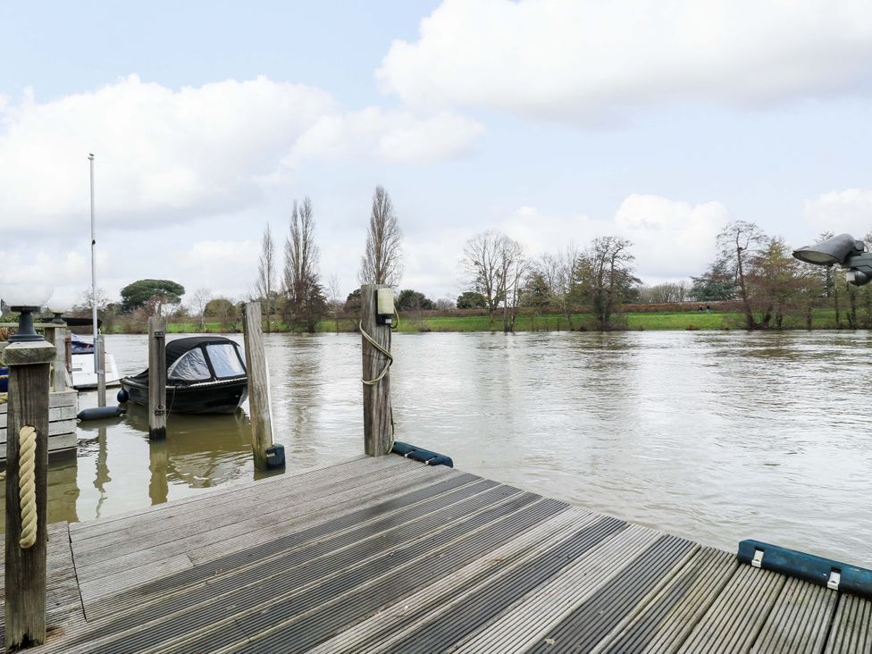 A dock with a boat and water at River Haven in Thames Ditton