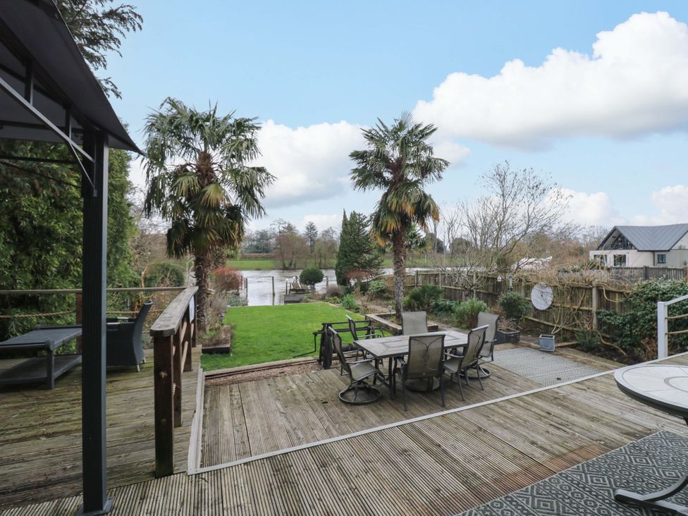 A garden with decking, table and chairs at River Haven in Thames Ditton