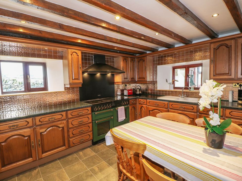 A kitchen with wooden cabinets and a table at Riber View Barn in Chesterfield