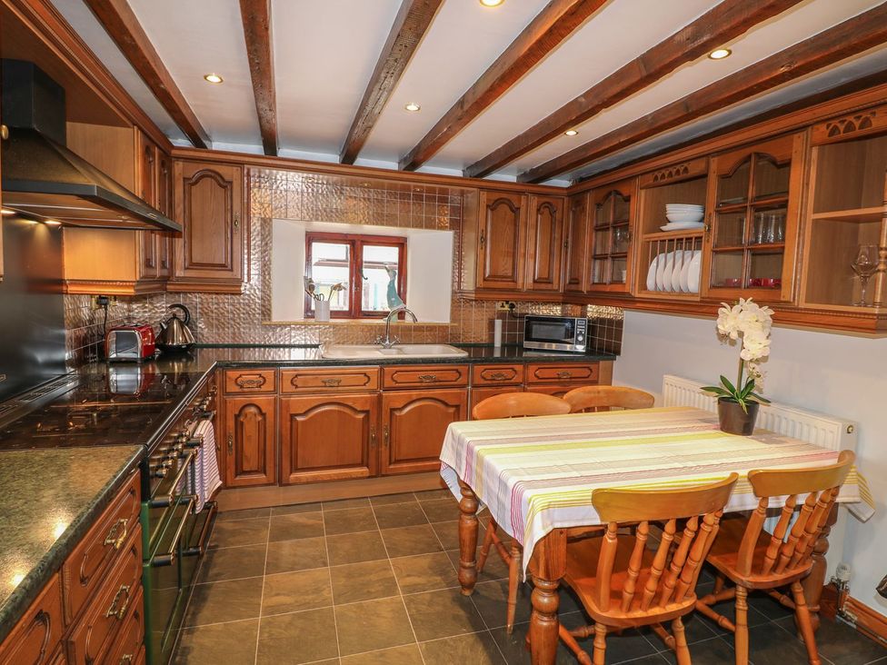 A kitchen with wooden cabinets and dining table at Riber View Barn Chesterfield