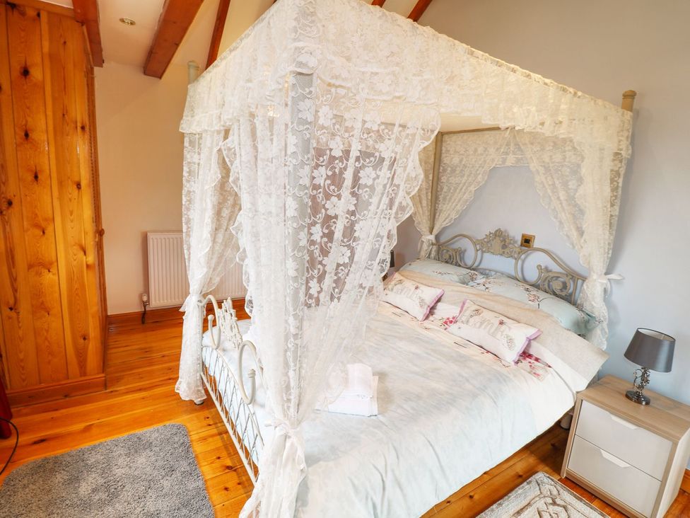 A bedroom with a canopy bed and wooden accents at Riber View Barn Chesterfield