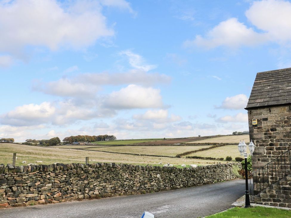 A landscape view with a stone wall and building at Riber View Barn Chesterfield