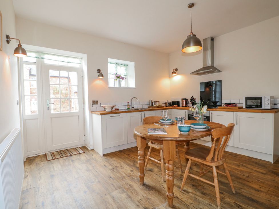 A kitchen with a dining table and chairs at America Lodge in Oakham