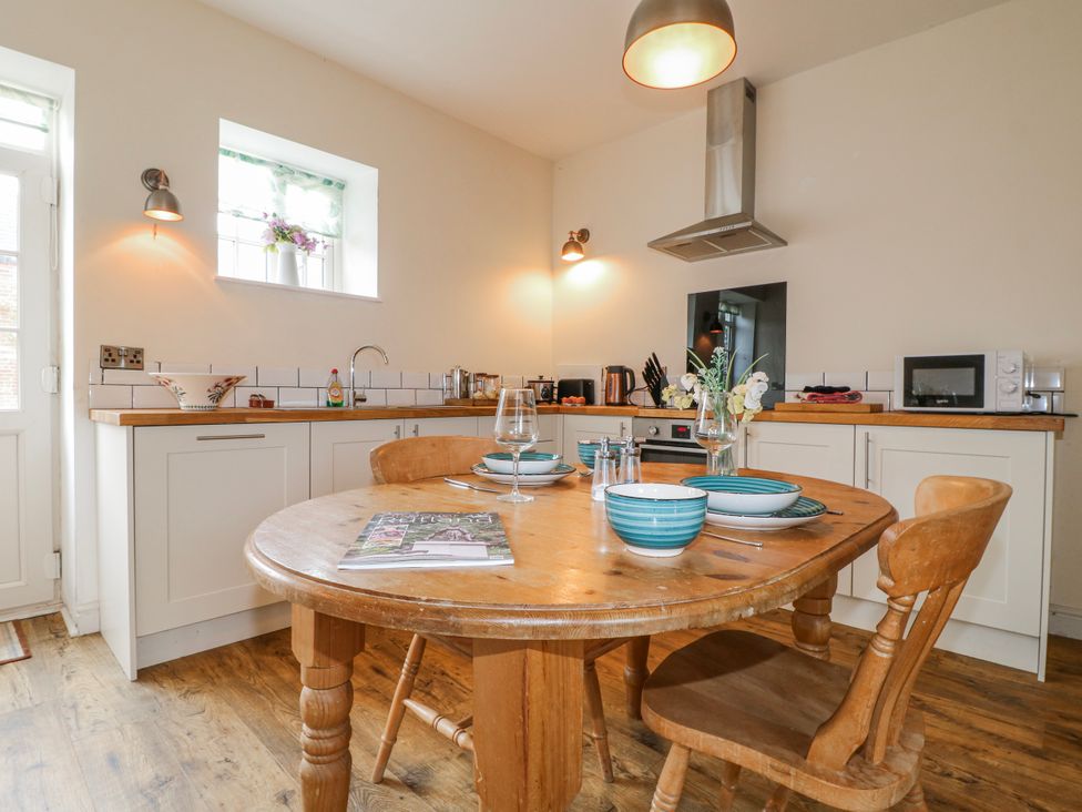 A kitchen with a round table and chairs at America Lodge in Oakham