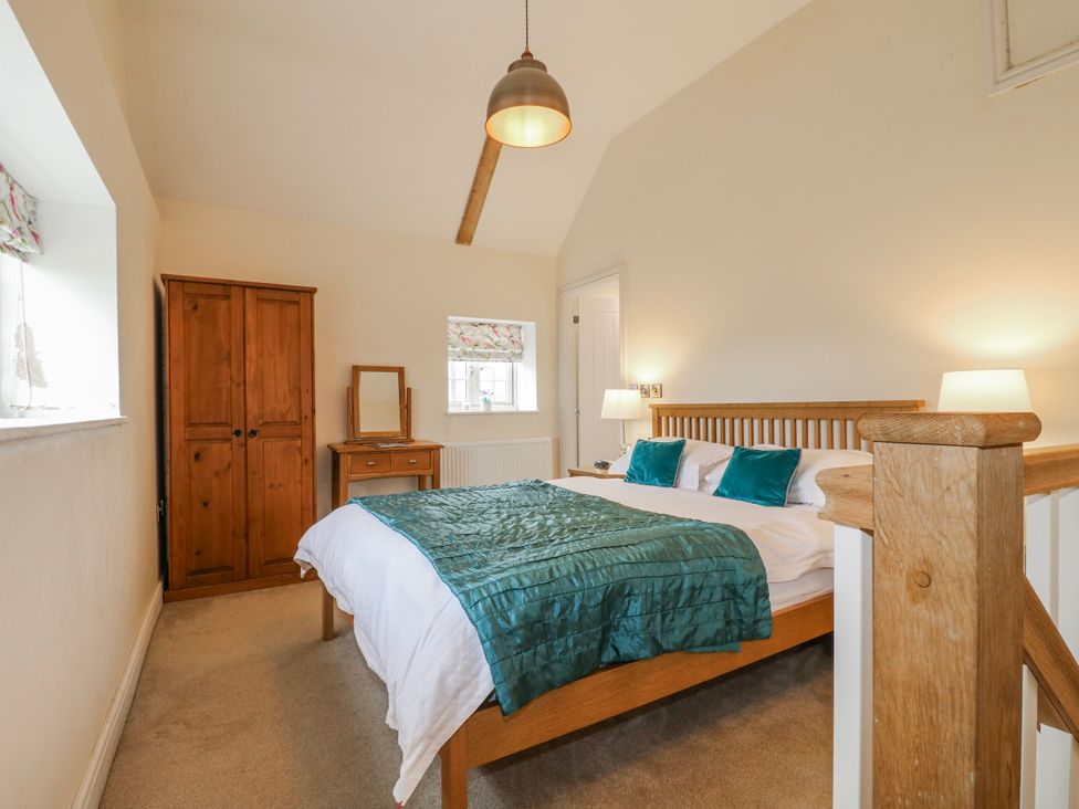 A bedroom with a wooden bed and wardrobe at America Lodge in Oakham