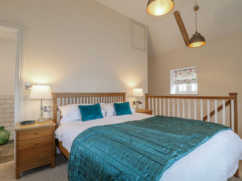 A bedroom with a bed and bedside table at America Lodge in Oakham