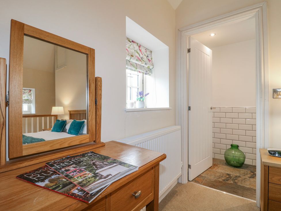 A bedroom with a dresser and mirror at America Lodge in Oakham