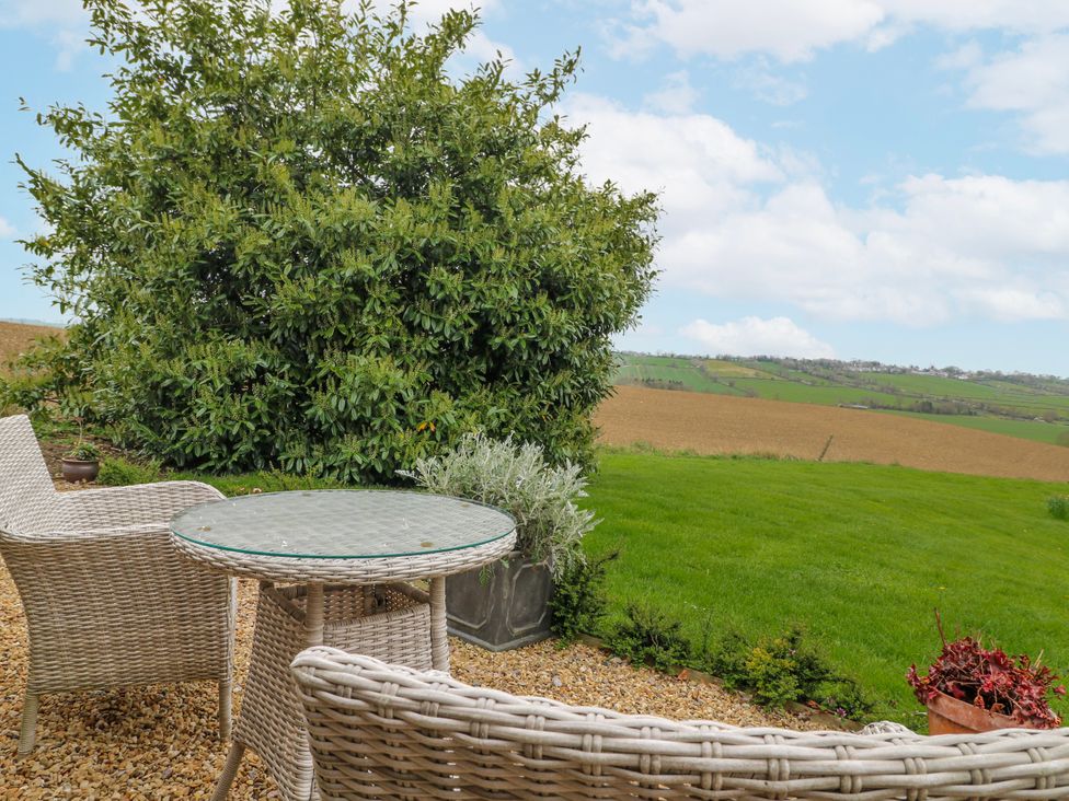A garden with seating and a view of the countryside at America Lodge in Oakham