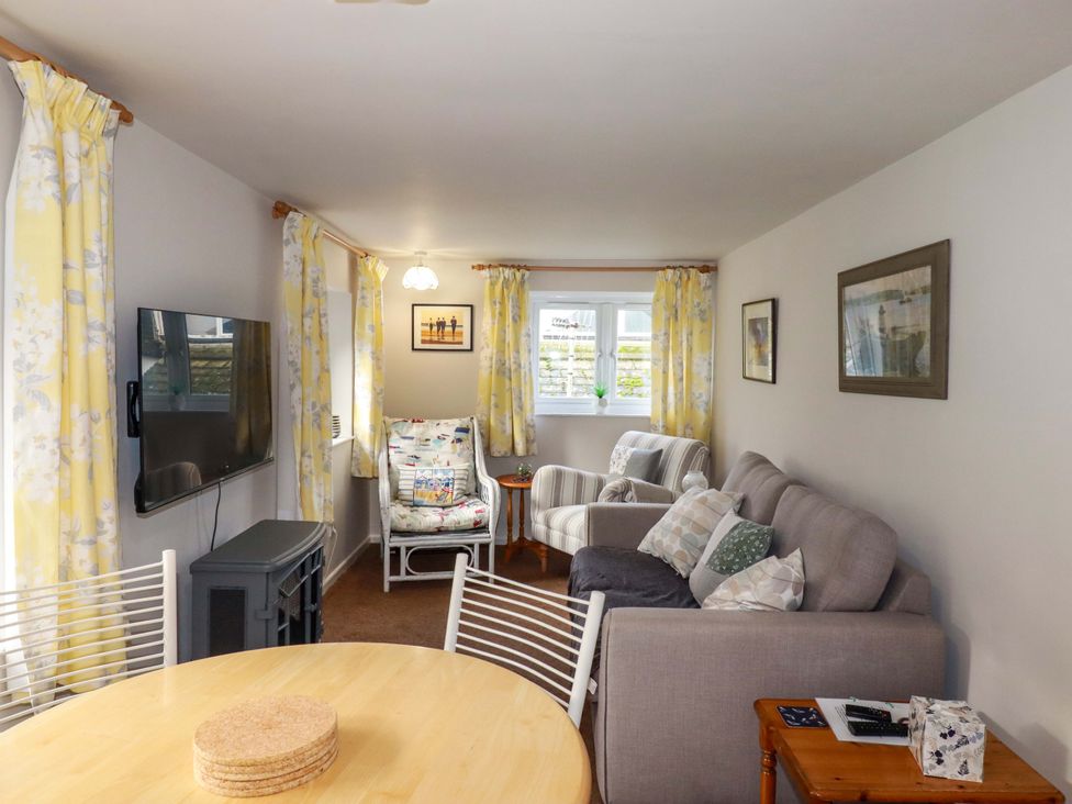 A living room with a television and a sofa at The Penthouse in Looe