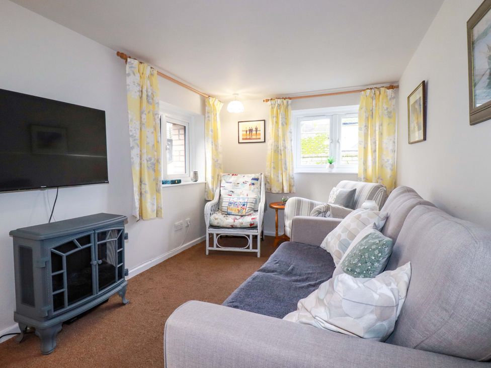 A living room with a sofa and television at The Penthouse in Looe