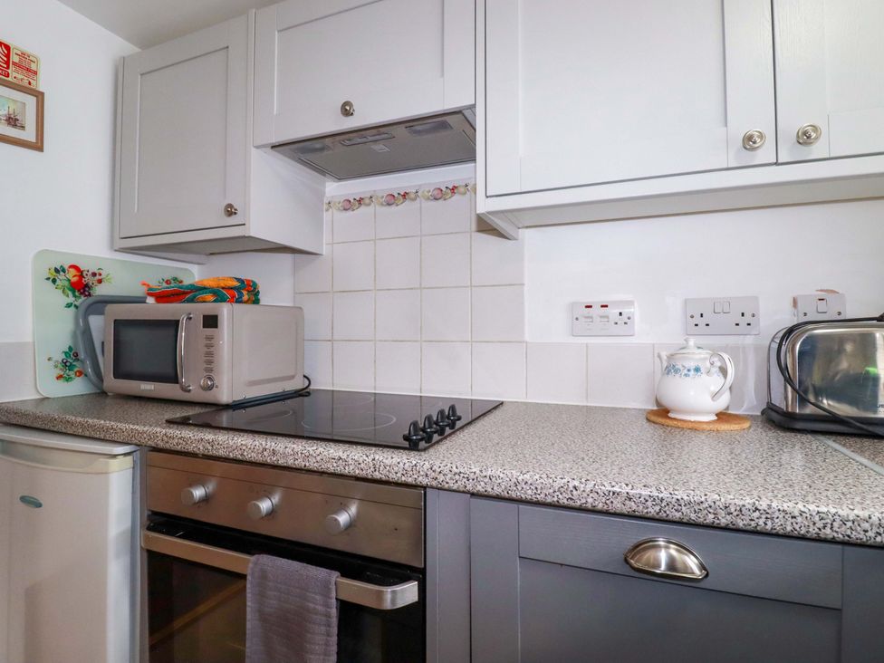 A kitchen with a microwave and oven at The Penthouse in Looe