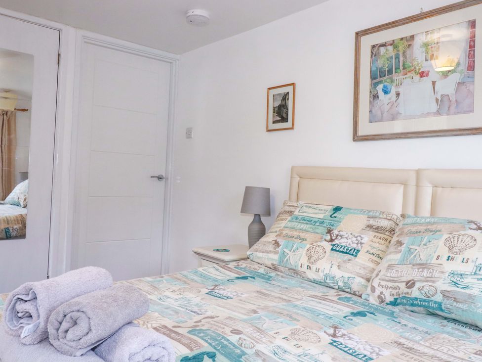 A bedroom with a bed and towels at The Penthouse in Looe