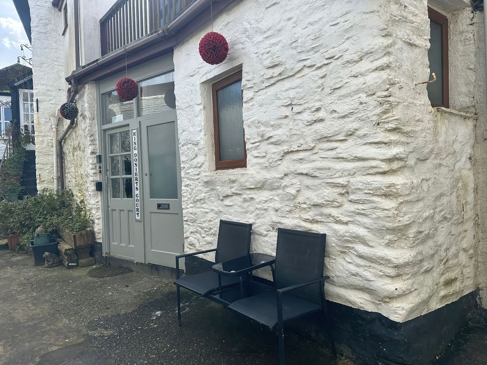An outdoor area with a door and chairs at The Penthouse in Looe