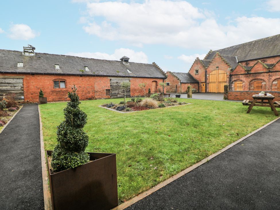 A garden with grass and flower beds at Courtyard View in Ashbourne