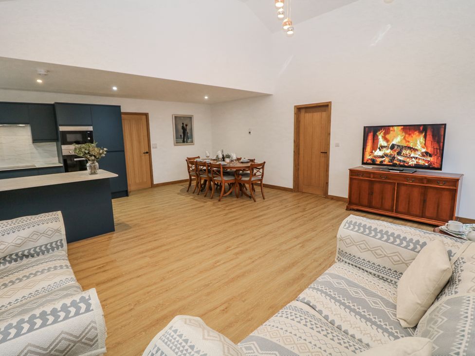 A living room with a dining table and kitchen counter at Courtyard View in Ashbourne