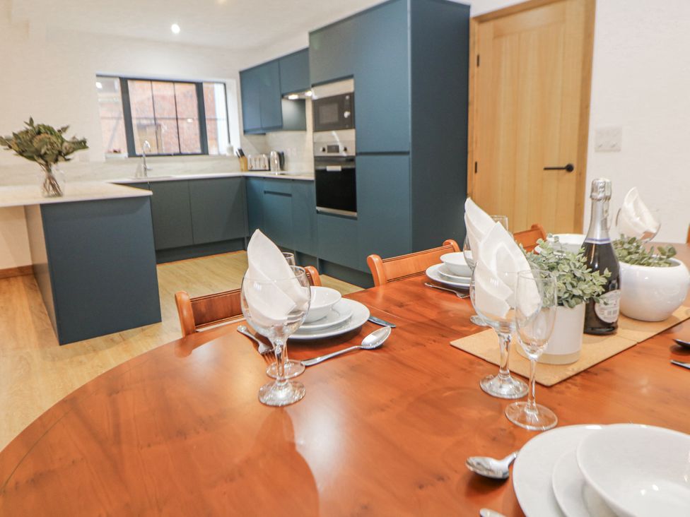 A kitchen with dining table and dishes at Courtyard View in Ashbourne