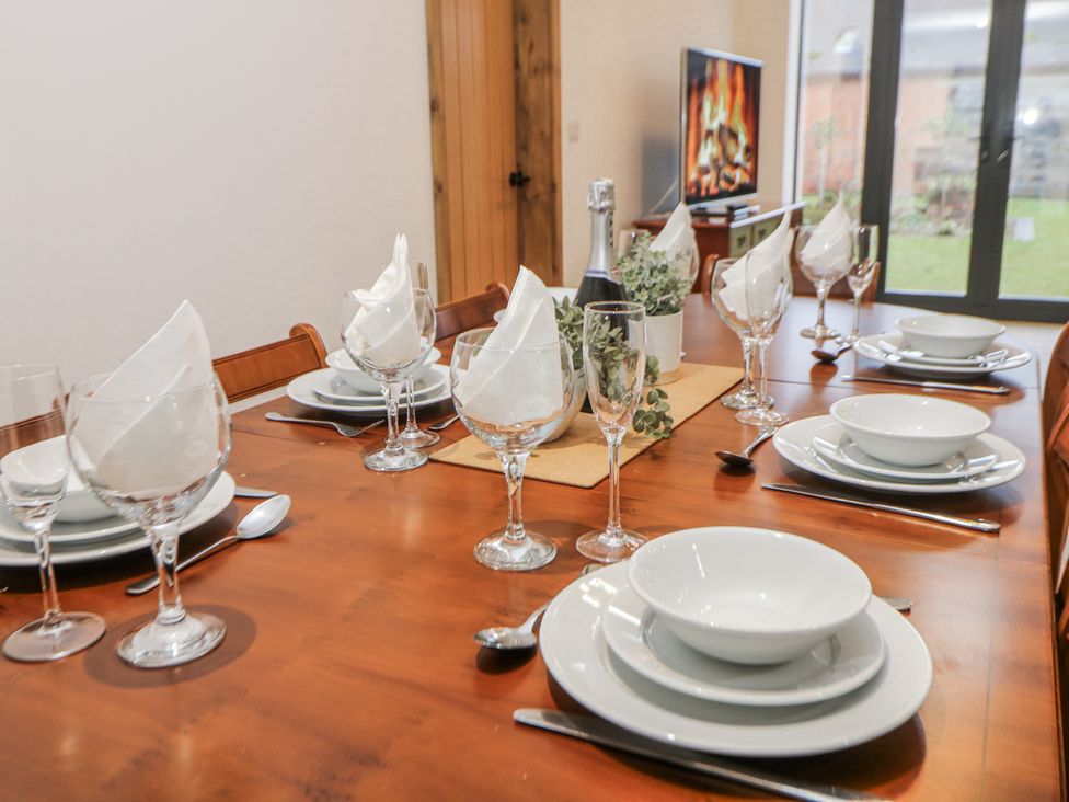 A dining table set with plates and glasses at Courtyard View in Ashbourne