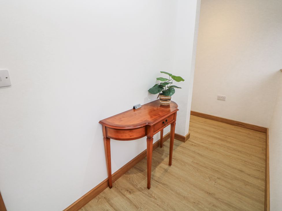 A console table with a plant in a hallway at Courtyard View Ashbourne