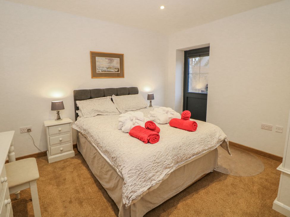 A bedroom with a bed and nightstands at Courtyard View in Ashbourne