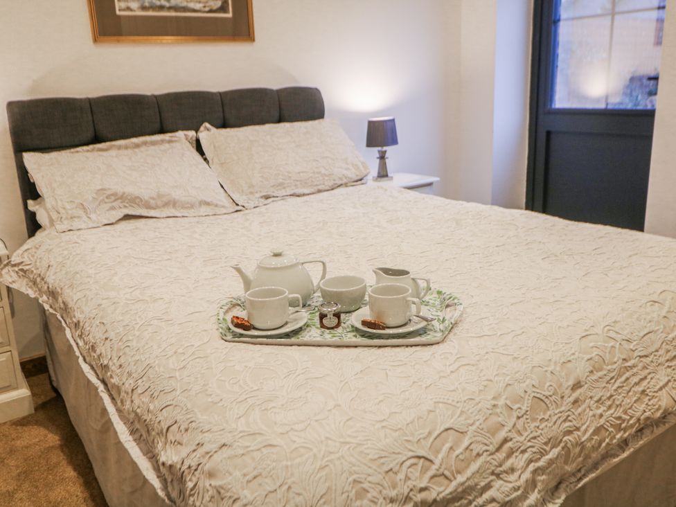 A bedroom with a bed and tea set at Courtyard View in Ashbourne