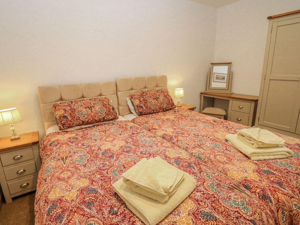 A bedroom with twin beds and lamps at Courtyard View in Ashbourne