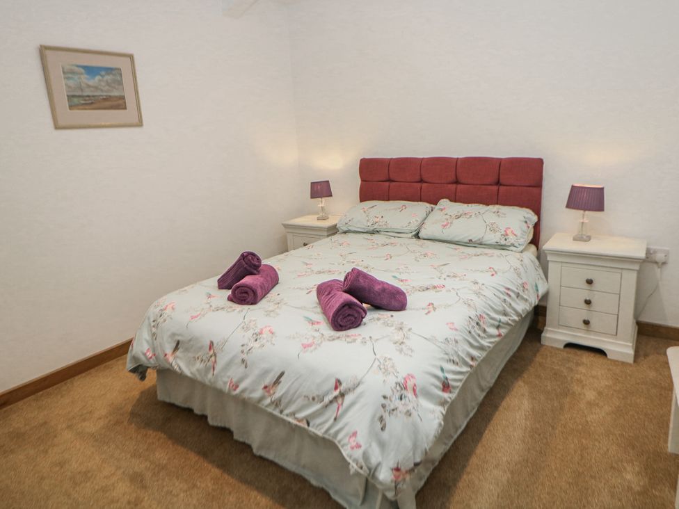 A bedroom with a bed and nightstands at Courtyard View in Ashbourne