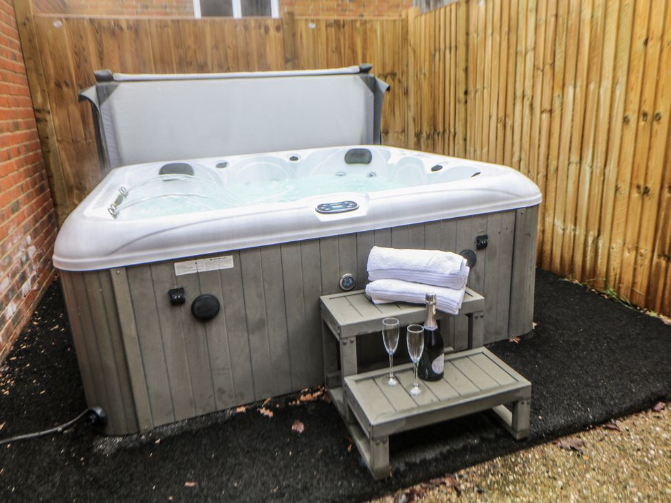 A hot tub with towels and champagne on a table at Courtyard View in Ashbourne