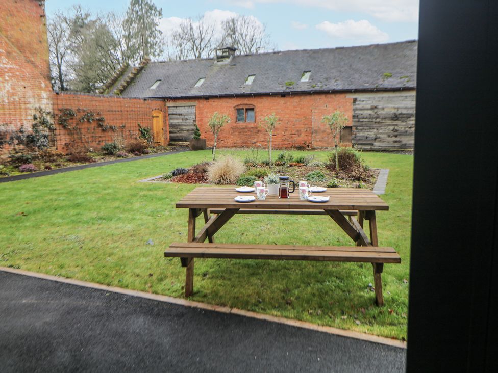 A table with plates and glasses in a garden at Courtyard View Ashbourne