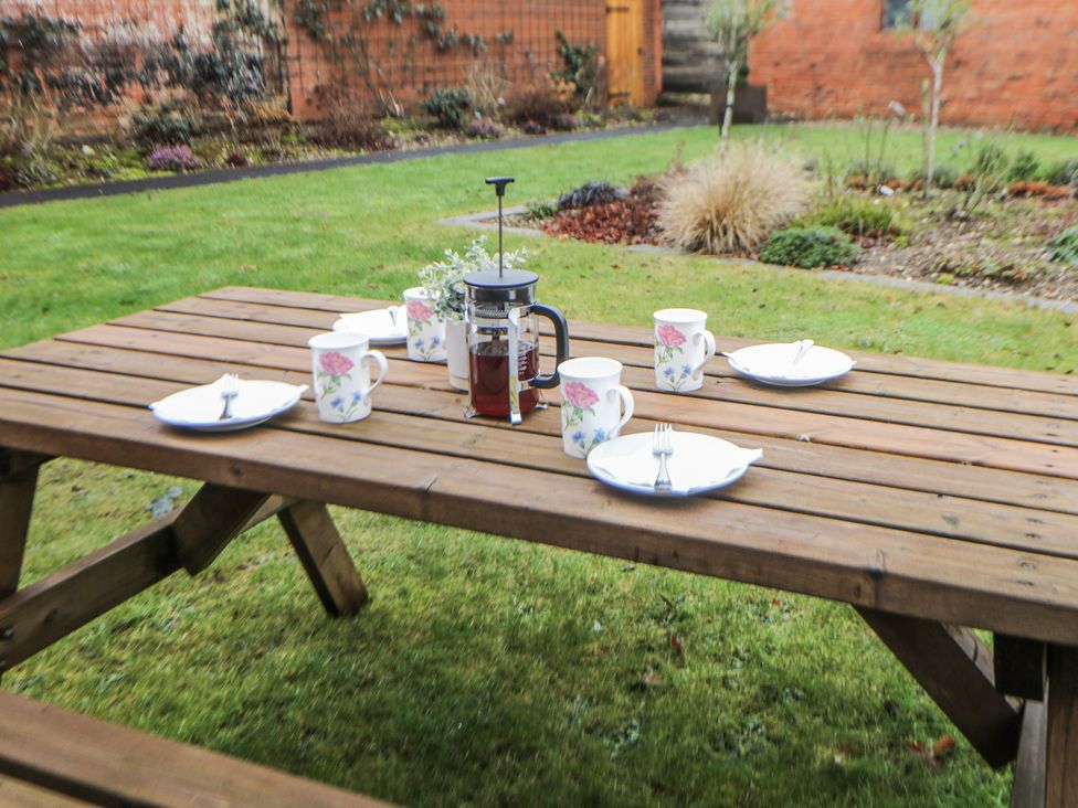 A table set for tea with mugs and plates at Courtyard View in Ashbourne