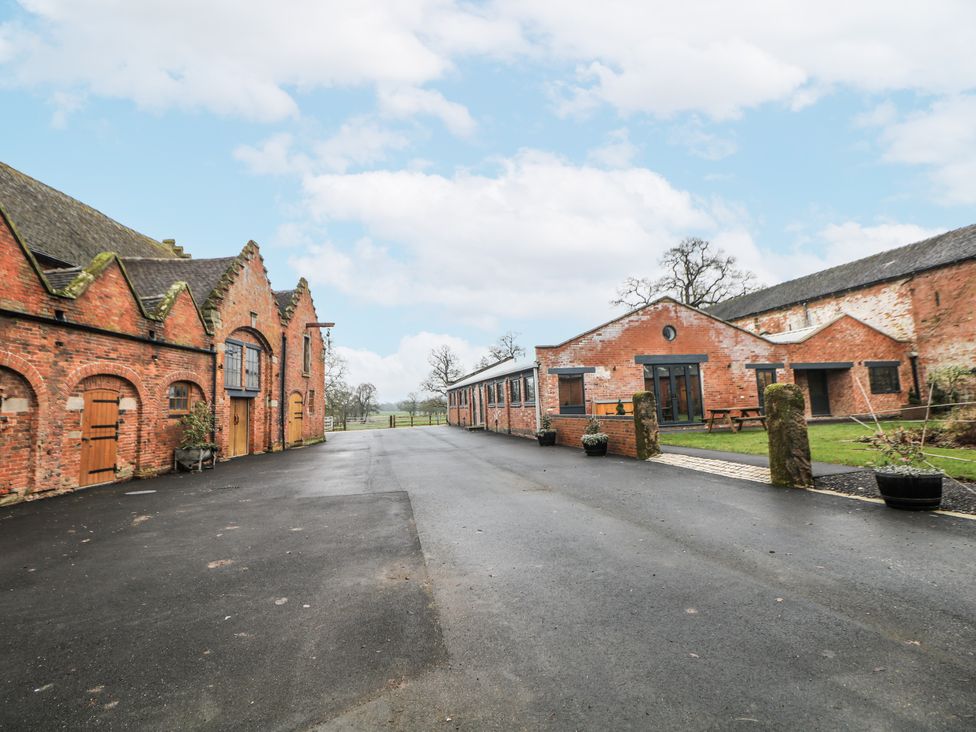 A courtyard area with brick buildings and outdoor seating at Courtyard View Ashbourne