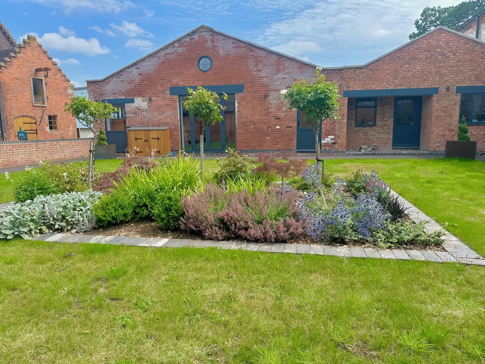 A garden with flowers and trees at Courtyard View in Ashbourne