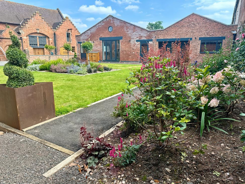 A garden with flowers and a pathway at Courtyard View in Ashbourne
