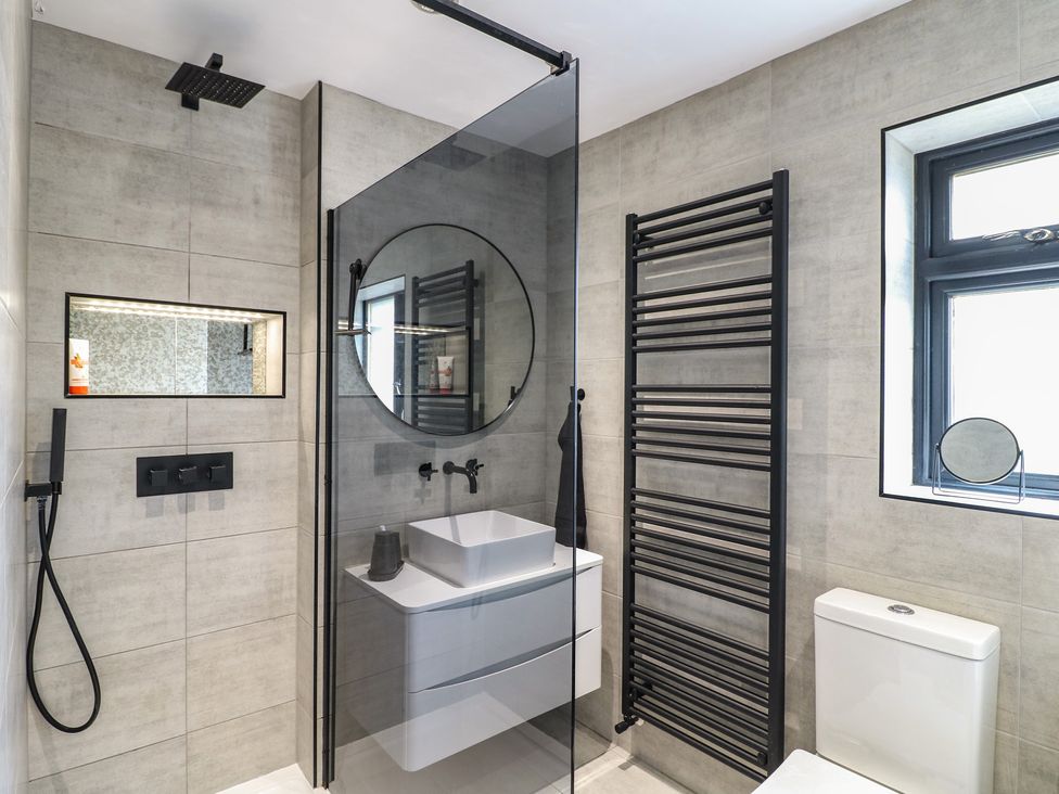 A bathroom featuring a shower, mirror, sink, towel rack, and toilet at 57 Howden Avenue Doncaster