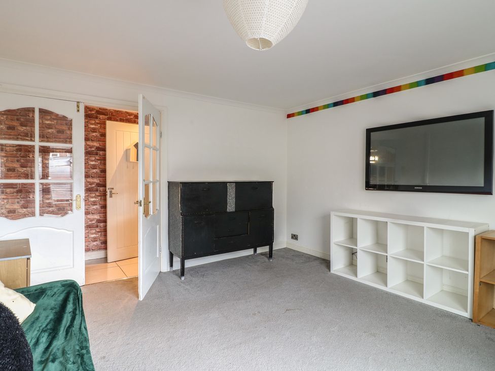 A living room with a cabinet and a television at 57 Howden Avenue Doncaster