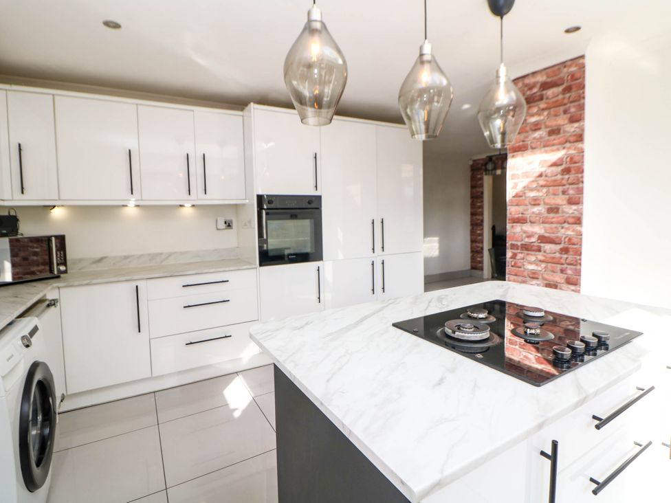 A kitchen with white cabinets and an island at 57 Howden Avenue in Skellow