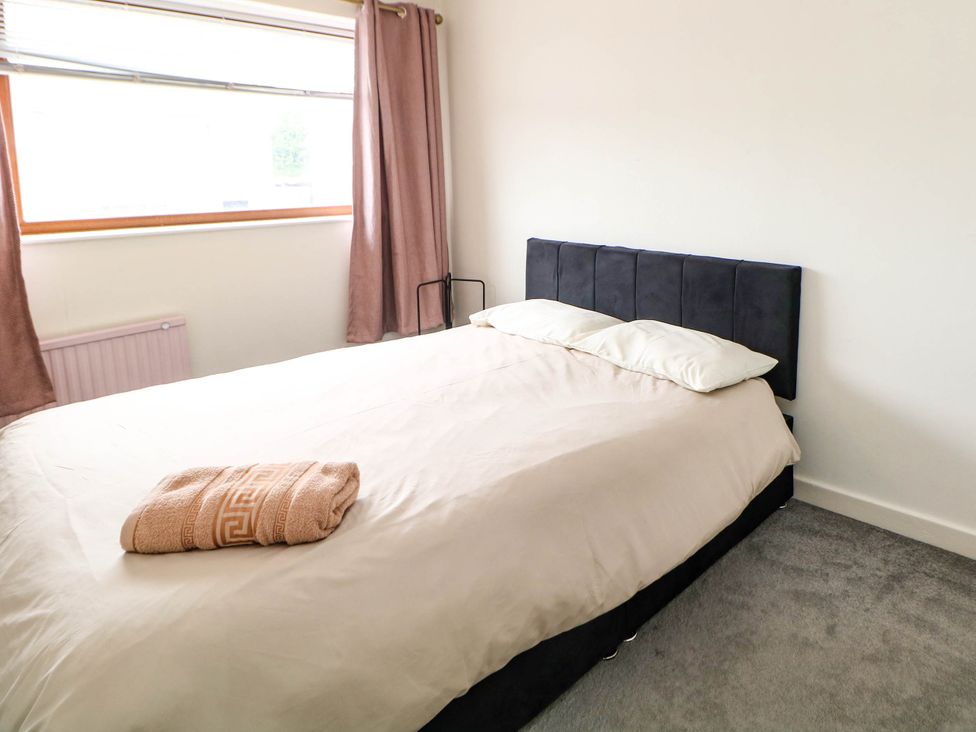 A bedroom with a bed and curtains at 57 Howden Avenue Skellow