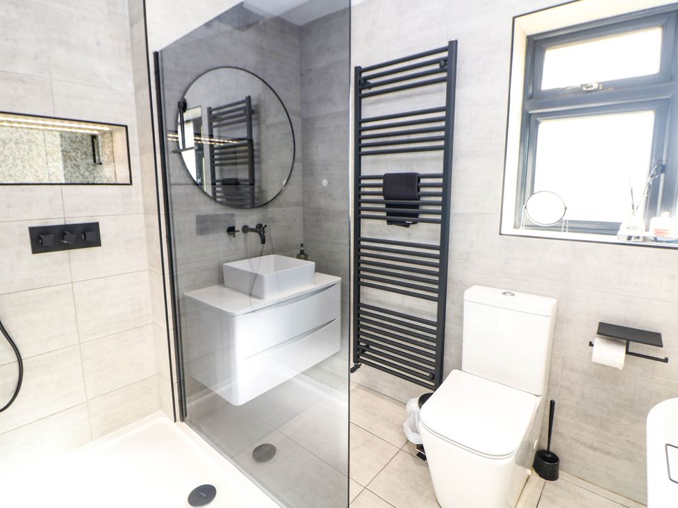 A bathroom with a shower, sink, toilet, and towel rail at 57 Howden Avenue Skellow