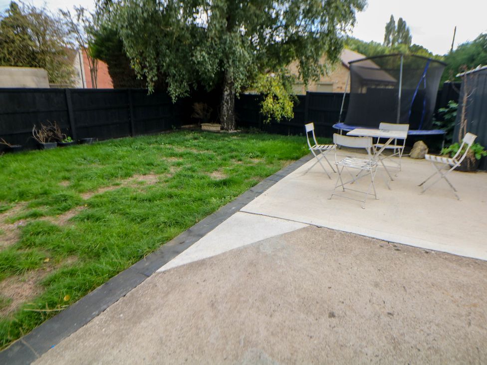 A garden with grass, a trampoline, and outdoor seating at 57 Howden Avenue Skellow
