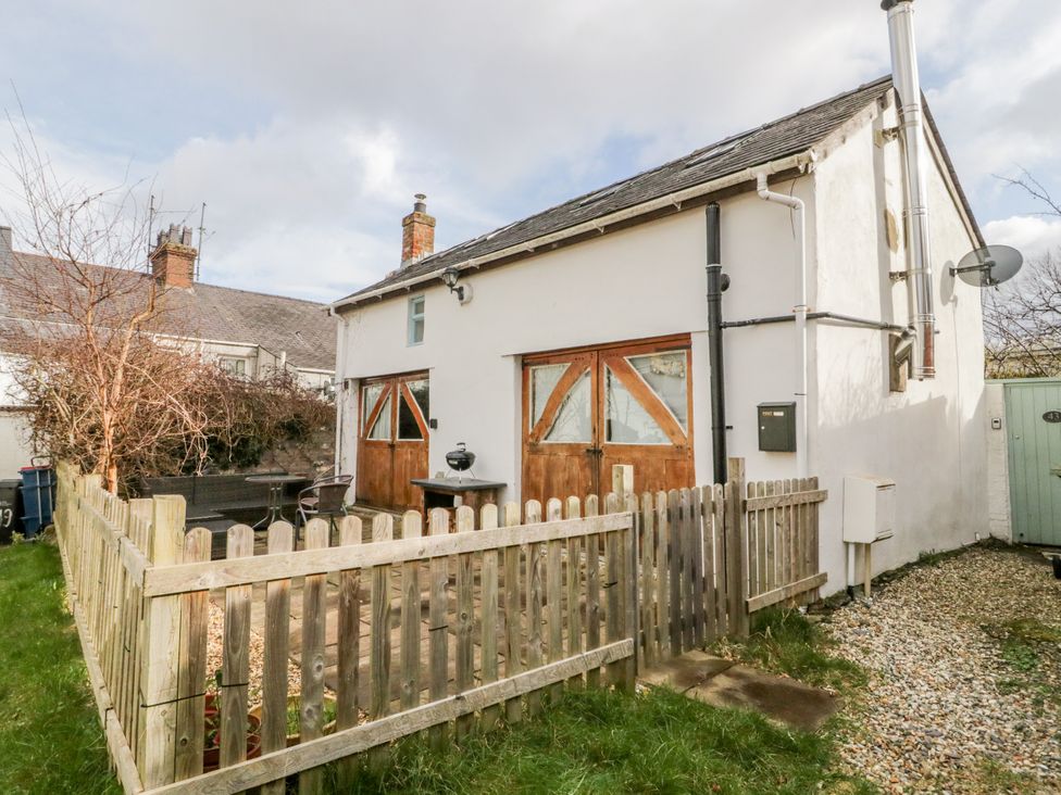 A house with wooden doors and a fenced area at Studio Bach in Beaumaris